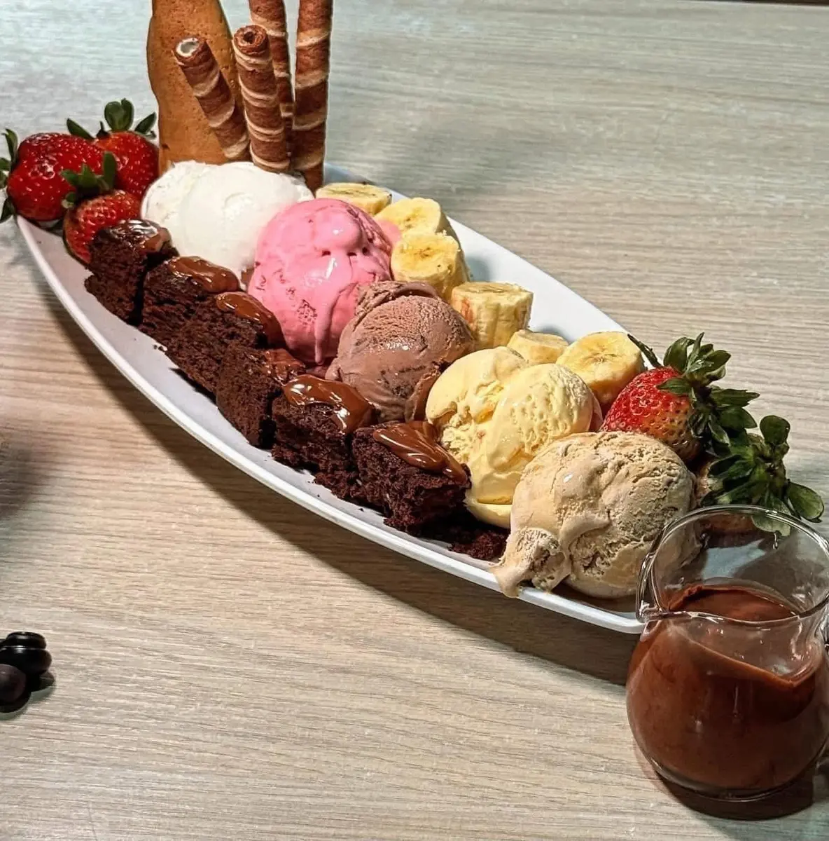 Postre tropical de Tropicool con helado, frutas y brownie